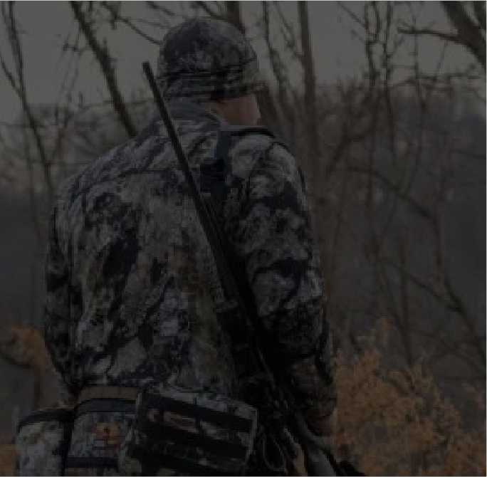 Hunter exploring a wooded backcountry landscape